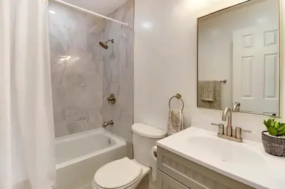a white bathroom with a toilet and a tub and a sink at Family fun at Casa Ledges in Tobyhanna
