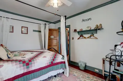 a bedroom with a bed with a striped comforter at Osceola Mill House Bed and Breakfast in Gordonville