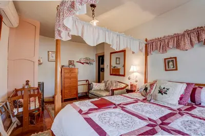 a bedroom with a large bed with a canopy at Osceola Mill House Bed and Breakfast in Gordonville