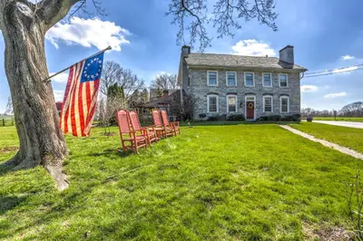 an american flag and chairs in front of a house at Osceola Mill House Bed and Breakfast in Gordonville