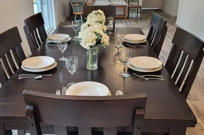 a table with plates and glasses and a vase of flowers at Serenity On The Lehigh River in Thornhurst