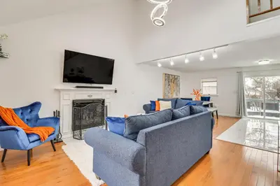 a living room with two blue couches and a fireplace at Chic Pocono Hideaway with Private Indoor Sauna in Long Pond