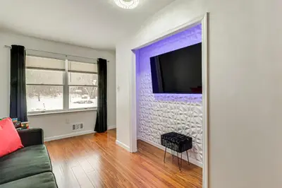a living room with a couch and a tv on a wall at Chic Pocono Hideaway with Private Indoor Sauna in Long Pond