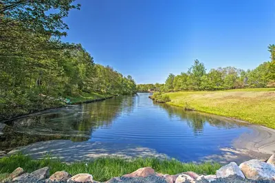 a river with rocks and trees on the side at Chic Pocono Hideaway with Private Indoor Sauna in Long Pond