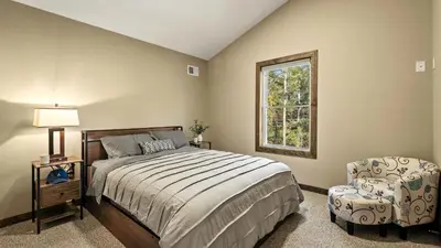 a bedroom with a bed and a chair and a window at Lakeview Sunset Heaven by AvantStay Waterfront Home • Hot Tub Game Room Discounted Ski Tickets in Blakeslee