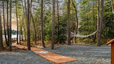a hammock in the woods next to a lake at Lakeview Sunset Heaven by AvantStay Waterfront Home • Hot Tub Game Room Discounted Ski Tickets in Blakeslee