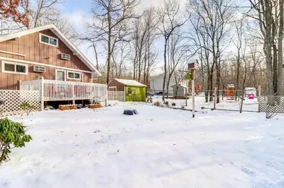 a house with a fence in the snow at 8 Mi to Big Boulder Mountain Cabin with Decks! in Albrightsville