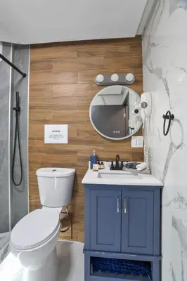 a bathroom with a blue cabinet and a mirror at 5 Bedroom Cozy Retreat Lakefront in Mount Zion
