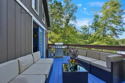 a patio with white couches and a grill at 5 Bedroom Cozy Retreat Lakefront in Mount Zion