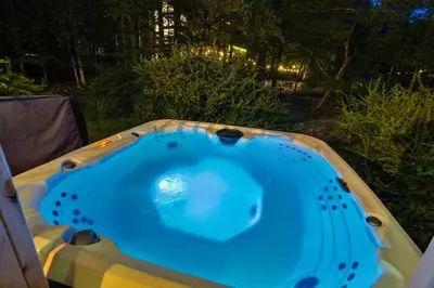 a jacuzzi tub in a backyard at night at 5 Bedroom Cozy Retreat Lakefront in Mount Zion