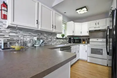 a kitchen with white cabinets and white appliances at 5 Bedroom Cozy Retreat Lakefront in Mount Zion