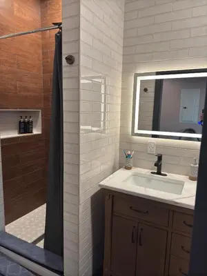 a bathroom with a sink and a shower with a mirror at NEW Modern Private Entrance 2 BD Apt Minutes to NYC in Jersey City