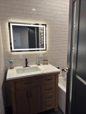 a bathroom with a sink and a mirror and a tub at NEW Modern Private Entrance 2 BD Apt Minutes to NYC in Jersey City