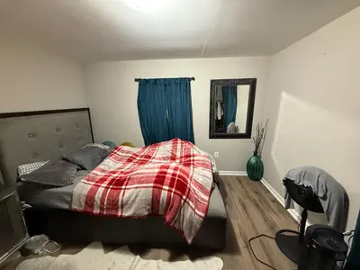 a bedroom with a bed with a plaid blanket at Cliffwood villa - 4 Bedroom House in Cliffwood Beach