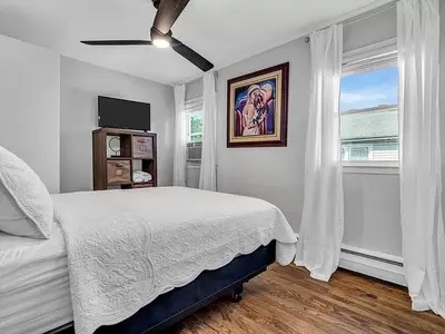 a white bedroom with a bed and a window at Suburban 3BR Stylish Oasis in Maplewood