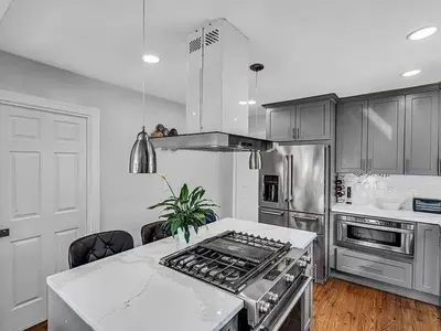 a kitchen with stainless steel appliances and a white counter top at Suburban 3BR Stylish Oasis in Maplewood