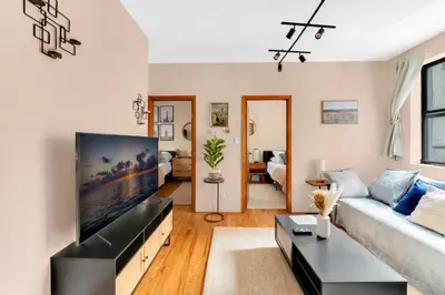 a living room with a large flat screen tv at Stylish 2 Bedroom Apartment in Chelsea in New York