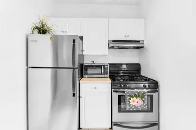 a kitchen with a refrigerator and a stove at Stylish 2 Bedroom Apartment in Chelsea in New York