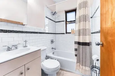a white bathroom with a toilet and a sink at Stylish 2 Bedroom Apartment in Chelsea in New York