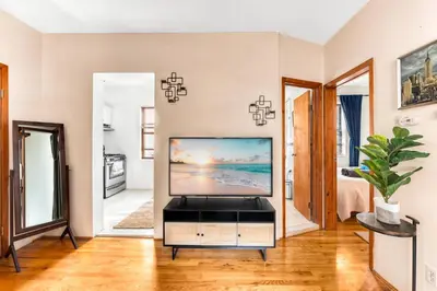 a living room with a flat screen tv on a cabinet at Stylish 2 Bedroom Apartment in Chelsea in New York