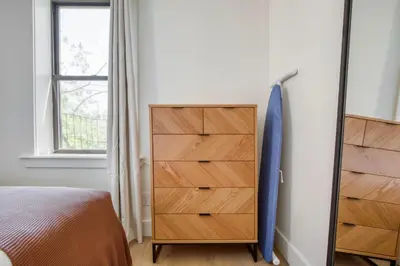 a bedroom with a chest of drawers and a window at Blueground E Village rooftop pool gym ac NYC-1533 in New York