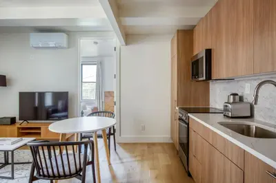 a kitchen with a table and chairs and a sink at Blueground E Village rooftop pool gym ac NYC-1533 in New York