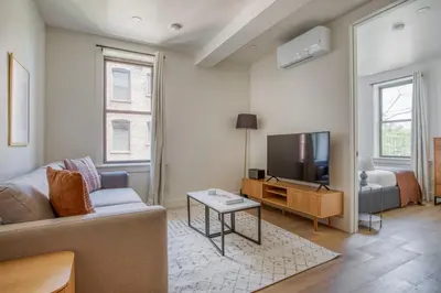 a living room with a couch and a tv at Blueground E Village rooftop pool gym ac NYC-1533 in New York