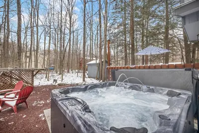 a hot tub in a yard with a chair and an umbrella at Peaceful Arrowhead Lakes Getaway Perfect for Spring and Summer Hot Tub Deck 3BR Home in Thornhurst