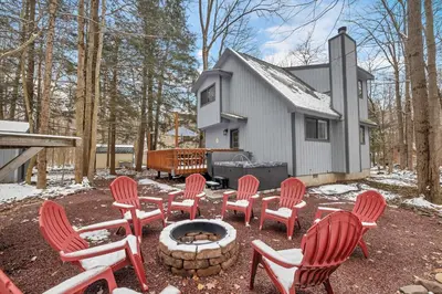 a group of chairs and a fire pit in front of a house at Peaceful Arrowhead Lakes Getaway Perfect for Spring and Summer Hot Tub Deck 3BR Home in Thornhurst