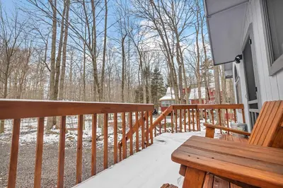 a wooden bench sitting on the porch of a house at Peaceful Arrowhead Lakes Getaway Perfect for Spring and Summer Hot Tub Deck 3BR Home in Thornhurst