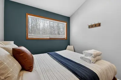 a bedroom with a bed and a window at Peaceful Arrowhead Lakes Getaway Perfect for Spring and Summer Hot Tub Deck 3BR Home in Thornhurst
