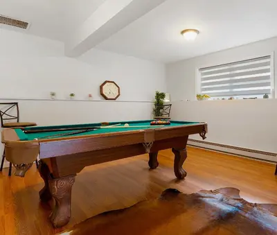 a room with a pool table and a clock on the wall at Gorgeous 4BR Home with Hot Tub,Pool& Sauna in East Stroudsburg