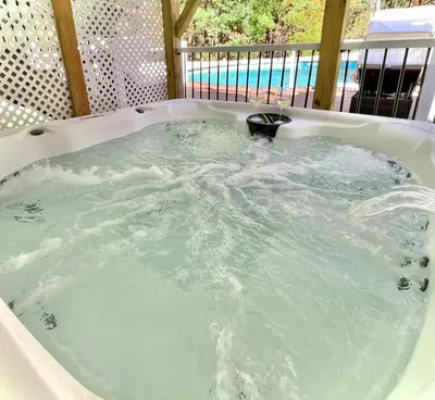 a jacuzzi bathtub filled with blue water at Gorgeous 4BR Home with Hot Tub,Pool& Sauna in East Stroudsburg