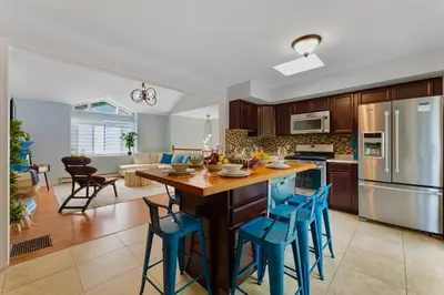 a kitchen with a large island with blue bar stools at Gorgeous 4BR Home with Hot Tub,Pool& Sauna in East Stroudsburg