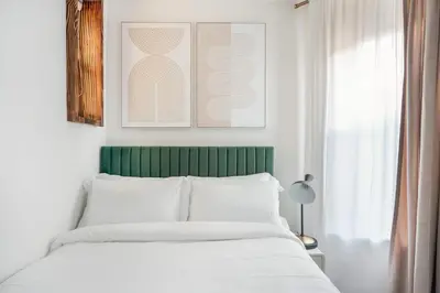 a bedroom with a white bed with a green headboard at 48-3FE 2BR Prime Midtown West in New York