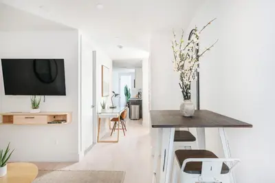 a living room with a table and a tv on a wall at 48-3FE 2BR Prime Midtown West in New York