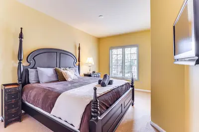 a bedroom with a large bed and a window at Boulder Lake Access Townhome with Deck! in Lake Harmony