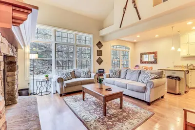 a living room with two couches and a table at Boulder Lake Access Townhome with Deck! in Lake Harmony