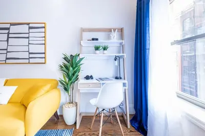 a living room with a yellow chair and a desk at 69-5C Festive Comfort Brand New 1BR Lower East Side Christmas Ready in New York