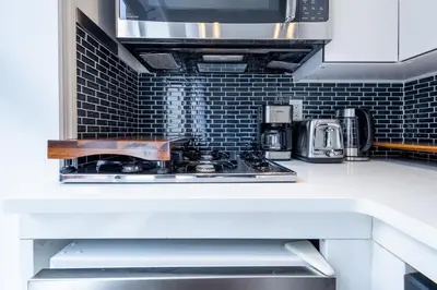 a kitchen counter with a stove top in a kitchen at 69-5C Festive Comfort Brand New 1BR Lower East Side Christmas Ready in New York