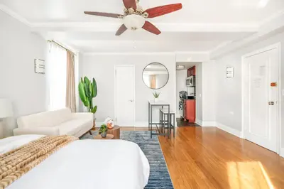 a bedroom with a ceiling fan and a living room at 73-1120 New Studio UWS Doorman Gym in New York