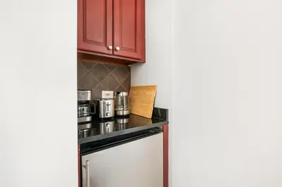 a kitchen with red cabinets and a counter at 73-1120 New Studio UWS Doorman Gym in New York