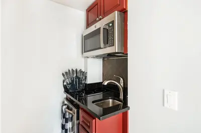 a kitchen with a sink and a microwave at 73-1120 New Studio UWS Doorman Gym in New York