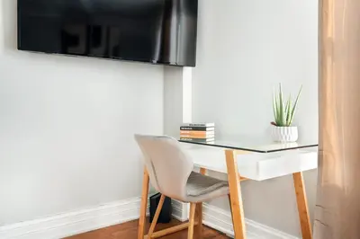 a desk with a chair and a television on a wall at 73-1120 New Studio UWS Doorman Gym in New York