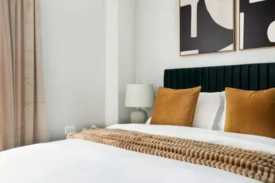 a bedroom with two beds with white and brown pillows at 73-1120 New Studio UWS Doorman Gym in New York