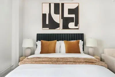 a bedroom with a large bed with orange pillows at 73-1120 New Studio UWS Doorman Gym in New York
