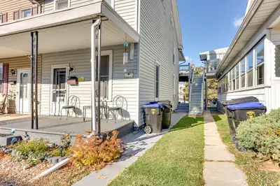a house with a porch with a table and two trash cans at HBG Apt about 3 Mi to Downtown and River! in Harrisburg