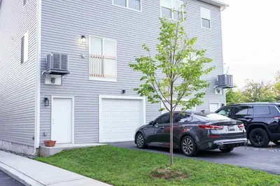 a car parked next to a house with a tree at Hidden Gem 2 in Norristown