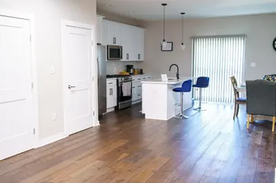 a kitchen and living room with white cabinets and a table at Hidden Gem 2 in Norristown