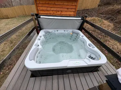 a hot tub sitting on top of a deck at Quiet Cottage In The Woods, with Hot Tub! in Glenmoore